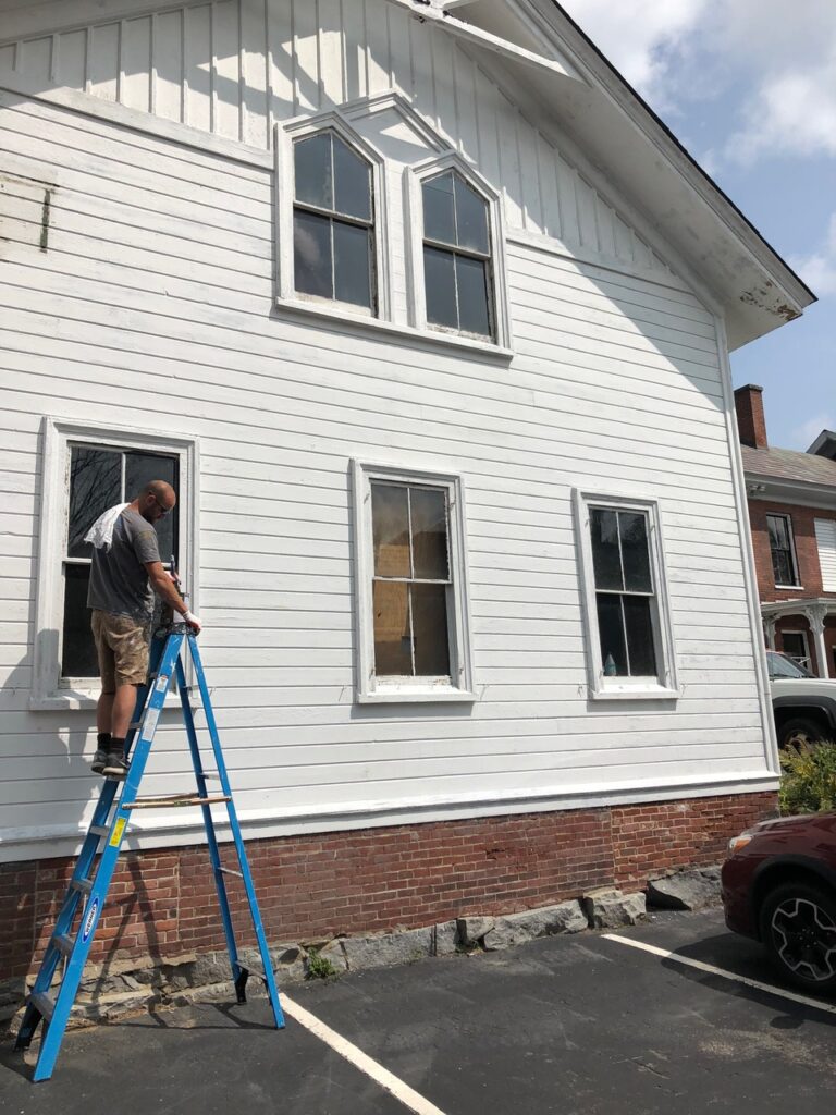 The carriage house getting a new coat of paint at The Burrell House Inn